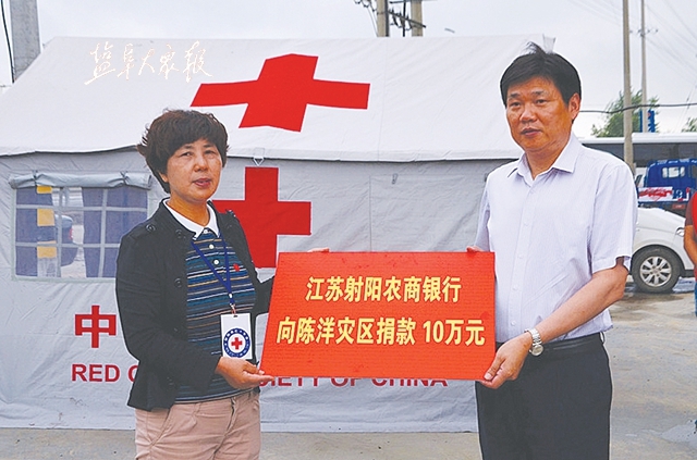 射阳农商行党委书记,董事长臧正志(右)代表该行向陈洋灾区高考成绩
