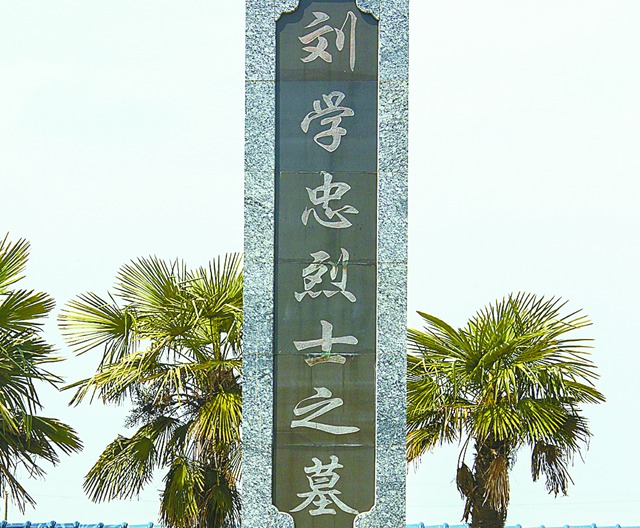 内,南团小学副校长刘启芹在大伯——刘学忠烈士墓前摆上一束鲜花后