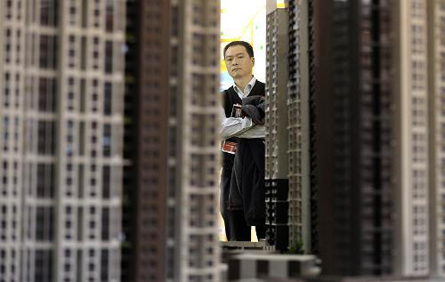 湖北省武汉市一名看房者在观看楼盘模型。新华社记者 程敏 摄