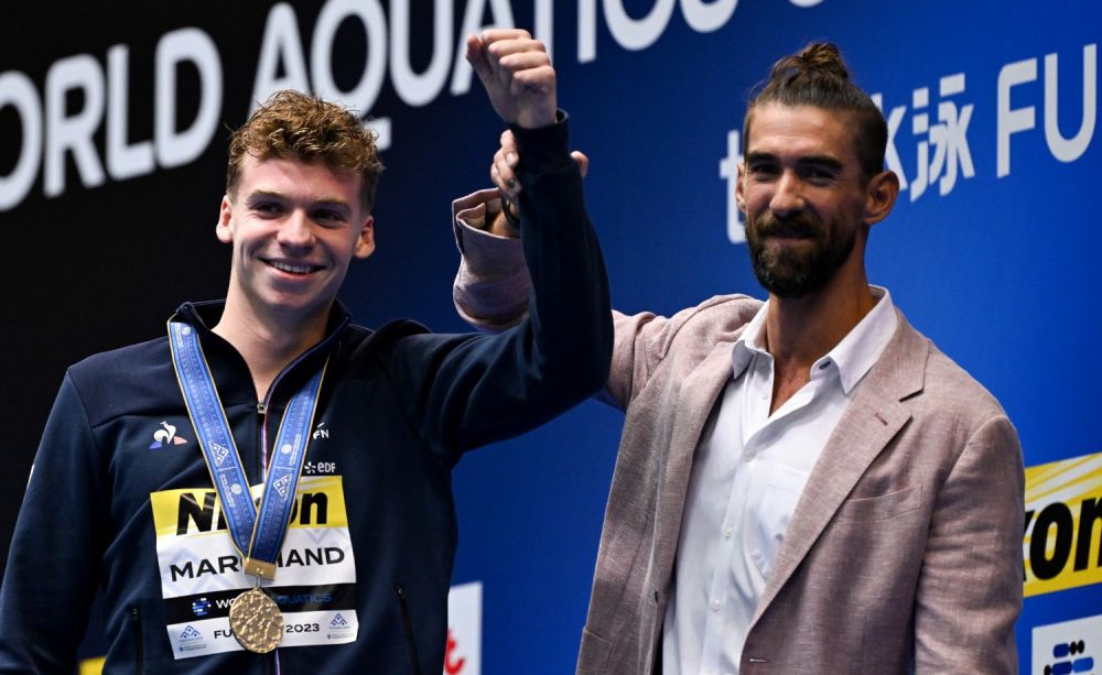 7月23日，法國選手馬爾尚 （左）和美國名將菲爾普斯在400米混合泳頒獎儀式上合影留念。新華社記者夏一方攝
