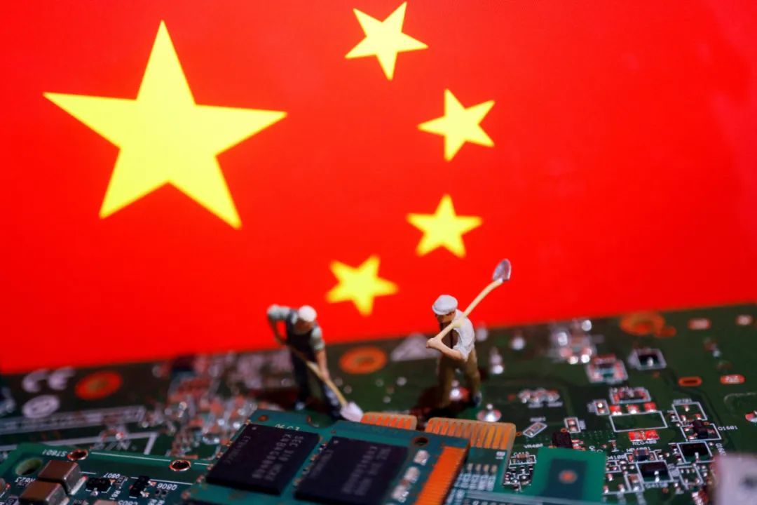 资料图片：在这张拍摄于7月5日的照片中，工人模型被放置在中国国旗和安装有芯片的电路板之间。（路透社）