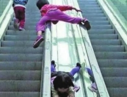 儿童电动扶梯上打闹危险 热心市民提醒家长假期看好孩子